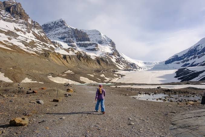 Traveller standing before Athabasca Glacier
